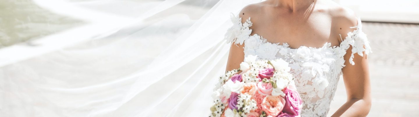 woman in white wedding dress holding bouquet of flowers